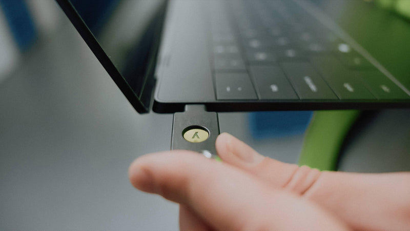 ノートパソコンのUSB-CポートにYubiKeyを挿し、金色の部分に指で触れる様子