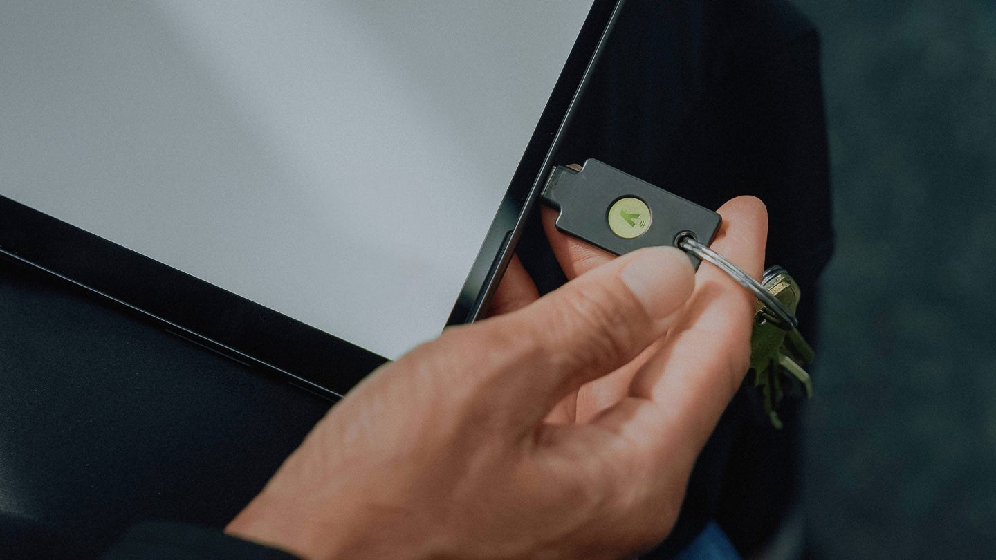 タブレットにYubiKeyをかざして認証しているところ