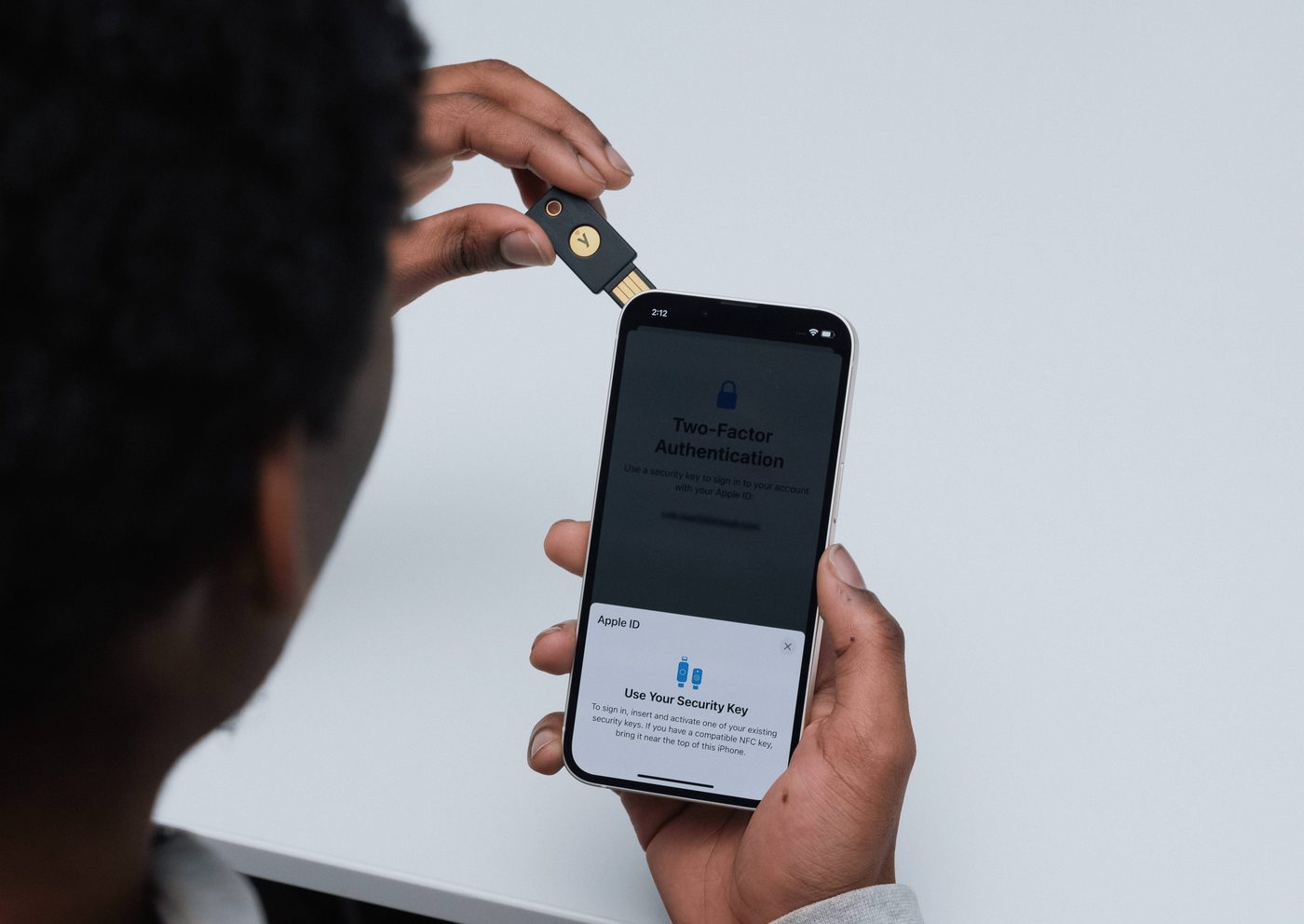 スマートフォンにYubiKeyをかざして認証する様子
